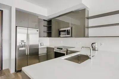 a white kitchen with a sink and a refrigerator at Blueground Brickell pool wd near city center MIA-127 in Miami