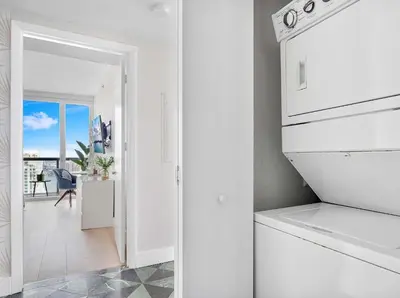 a white kitchen with a view of a balcony at MVR-Relax in Style Above Brickell in Miami