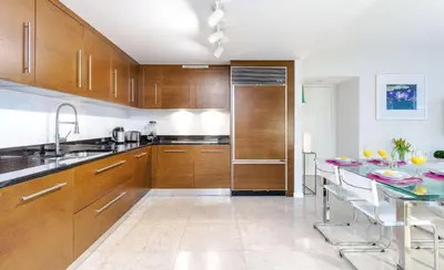 a kitchen with wooden cabinets and a table with chairs at MVR-Icon Brickell High-Rise w Balcony in Miami