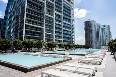 a large swimming pool with lounge chairs and tall buildings at MVR-Designer Stay in Heart of Brickell in Miami