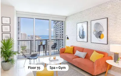 a living room with a orange couch and a large window at MVR - Floor 45 Views & Spa Bliss in Miami