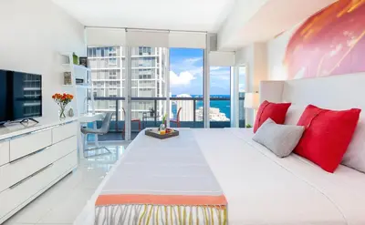 a bedroom with a large white bed with red pillows at MVR - Where Views Meet Vibes in Miami in Miami