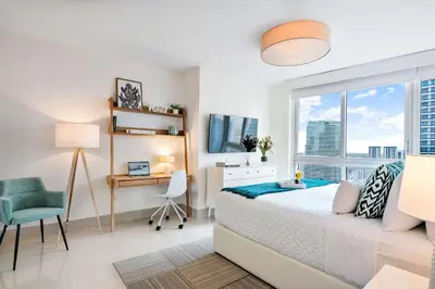 a bedroom with a bed and a desk and a window at MVR - Designer Condo in Prime Brickell in Miami