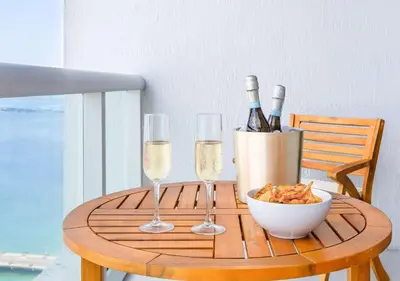 a table with two glasses of wine and a bowl of food at MVR - Wake to Water & Skyline Views in Miami