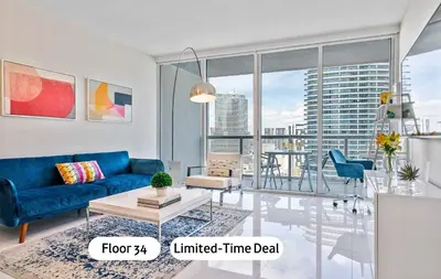 a living room with a blue couch and a table at MVR - Icon Brickel River & Bay Views in Miami