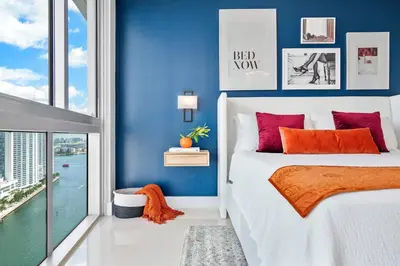 a bedroom with blue walls and a bed with red pillows at MVR - Icon Brickell Beauty with Views in Miami
