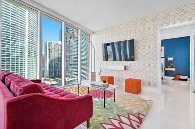 a living room with a purple couch and large windows at MVR - Icon Brickell Beauty with Views in Miami
