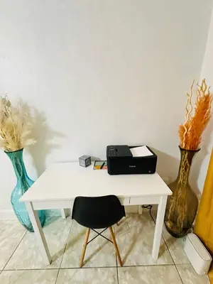 a white desk with a black briefcase on it next to vases at Miami Casa in Miami Gardens