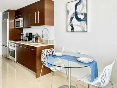 a dining room with a glass table and chairs at MVR Brickell Gem w Designer Touches in Miami