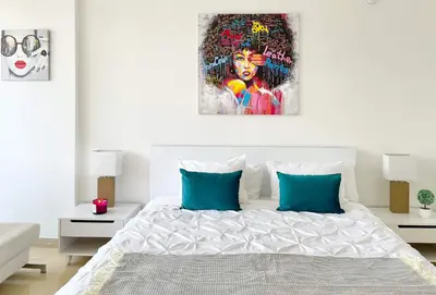 a bedroom with a bed with a painting on the wall at MVR Brickell Gem w Designer Touches in Miami