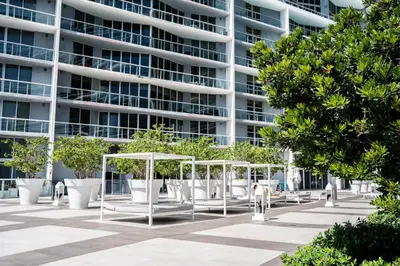 a building with trees and benches in front of it at MVR - Live the Icon Brickell Dream in Miami