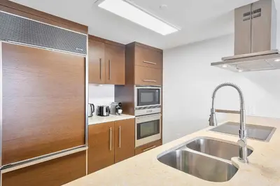 a kitchen with wooden cabinets and a stainless steel sink at MVR - Top-Tier Brickell High-Rise Stay in Miami
