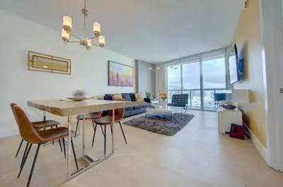 a dining room and living room with a table and chairs at MVR Balcony Bliss in Miami in Miami