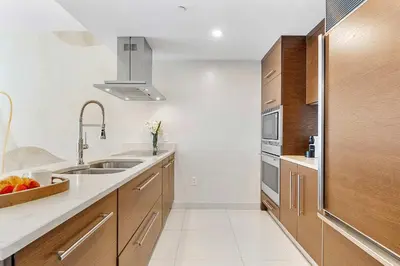 a kitchen with wooden cabinets and a sink at MVR - Wake Up to Brickell-s Best Views in Miami