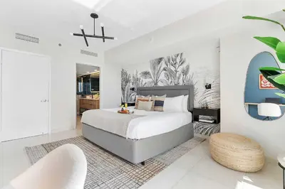 a bedroom with a large bed and two chairs at MVR - Wake Up to Brickell-s Best Views in Miami