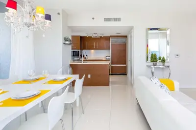 a white dining room with a white table and white chairs at MVR - High-Floor Luxury with Iconic Views in Miami