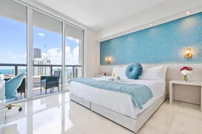 a bedroom with a large bed with a blue wall at MVR - Designer Stay in Sky-High Tower in Miami