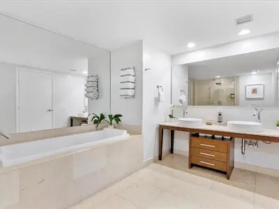 a bathroom with two sinks and a tub and a large mirror at MVR - Bay & City Views from the 45th in Miami