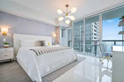 a bedroom with a white bed and a large window at MVR - Icon Brickell & King Suite Views in Miami