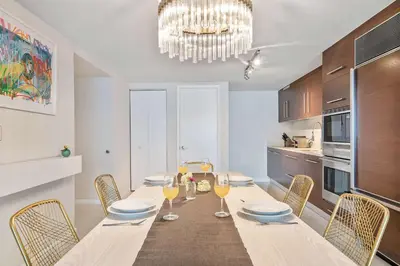 a dining room with a table with chairs and a chandelier at MVR - Icon Brickell & King Suite Views in Miami
