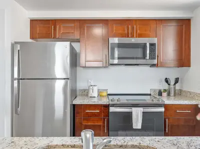 a kitchen with stainless steel appliances and wooden cabinets at MVR - Coconut Grove-s Oasis of Comfort and Elegance in Miami