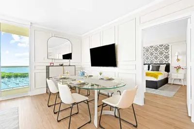 a white living room with a table and chairs at MVR - Steps from Miami-s Top Attractions in Miami