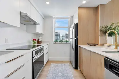 a kitchen with white cabinets and a black refrigerator at MVR-No More Hassles-Just Peace & Luxury in Miami