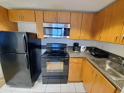 a kitchen with a black refrigerator and a sink at 1 Bed on Collins Av close to Beach in Miami Beach