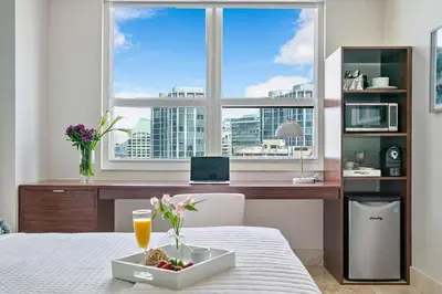 a table with a bowl of fruit and a desk with a window at MVR - Where Families and Professionals Align in Miami