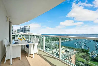 a balcony with a table and chairs and a view of the water at MVR-Coconut Grove-s Best Kept Secret-Revealed in Miami
