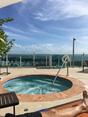 a man laying on a bench in a swimming pool at MVR - Elevate Your Stay with Panoramic Bay Views in Miami
