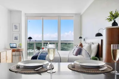 a table with two plates and glasses of wine at MVR-Sunset Luxury You Can-t Find Anywhere Else in Miami