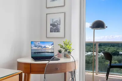 a laptop computer sitting on a desk in front of a window at MVR-Sunset Luxury You Can-t Find Anywhere Else in Miami