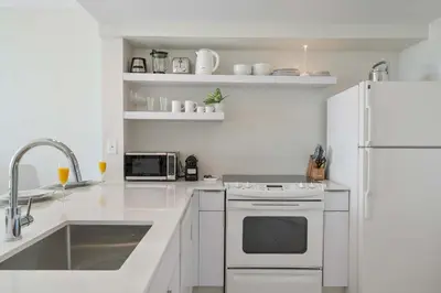 a white kitchen with a sink and a refrigerator at MVR-Your Gateway to Miami-s Culture & Calm in Miami