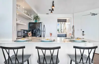 a kitchen with a bar with three chairs and a counter top at MVR - Longest Rooftop Pool in Florida-Yours in Miami