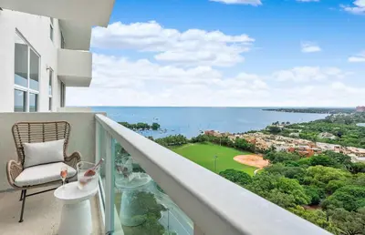 a balcony with a chair and a view of the ocean at MVR - Longest Rooftop Pool in Florida-Yours in Miami