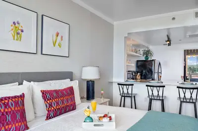 a bedroom with a bed and a kitchen with chairs at MVR - Longest Rooftop Pool in Florida-Yours in Miami