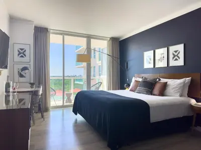 a bedroom with a bed and a table and a window at MVR-Your Escape Your View Your Grove in Miami