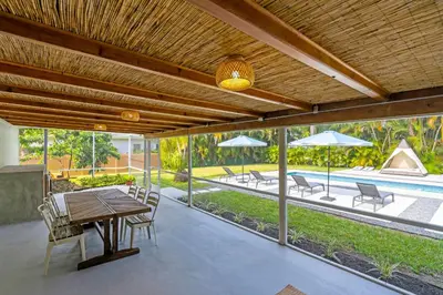 a patio with a table and chairs and a pool at 4BR Biscayne River Home with Pool & Pickleball Fun in Biscayne Gardens