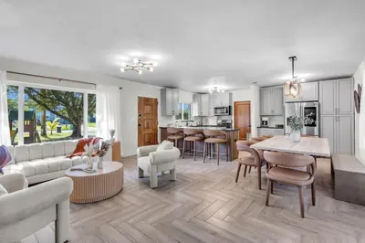 a living room with a couch and a table at 4BR Biscayne River Home with Pool & Pickleball Fun in Biscayne Gardens