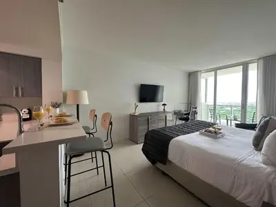 a hotel room with a bed and a kitchen with a table at MVR - Gorgeous Views and Refined Living Spaces in Miami