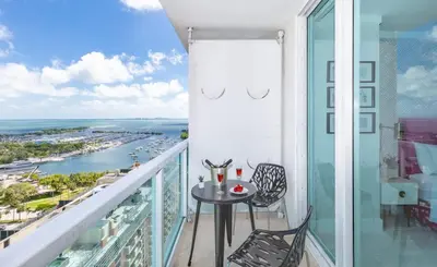 a balcony with a table and chairs and a view of the ocean at MVR - Experience Life Above the Miami Skyline in Miami