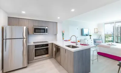 a kitchen with a white refrigerator and a bed at MVR - Experience Life Above the Miami Skyline in Miami