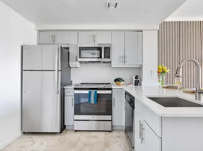 a white kitchen with white cabinets and a sink at MVR - Where Style Comfort and Convenience Meet in Miami