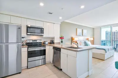 a kitchen with white cabinets and a bed in a room at MVR - The Best of Work Relaxation in One in Miami
