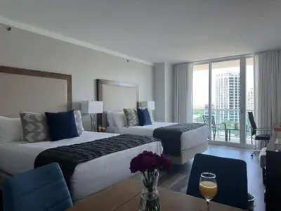 a hotel room with two beds and a table at MVR-Modern Touches Coconut Grove Warmth in Miami