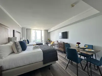 a hotel room with a bed and a dining room at MVR-Modern Touches Coconut Grove Warmth in Miami