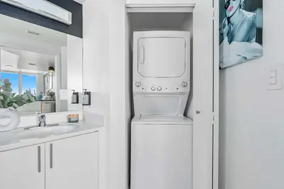 a white bathroom with a washer and dryer at MVR - Designed for Design Lovers Who Travel in Miami