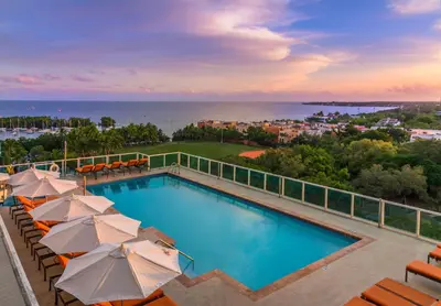 a swimming pool with umbrellas and the ocean at MVR - Elevate Your Stay with Stunning Ocean Views in Miami