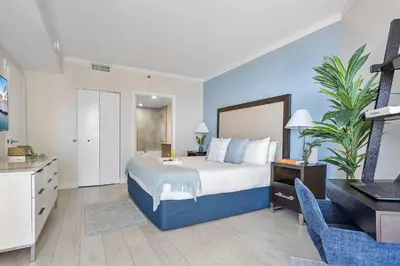 a bedroom with a bed and a desk with a laptop at MVR - Sunsets So Good You-ll Book Twice in Miami